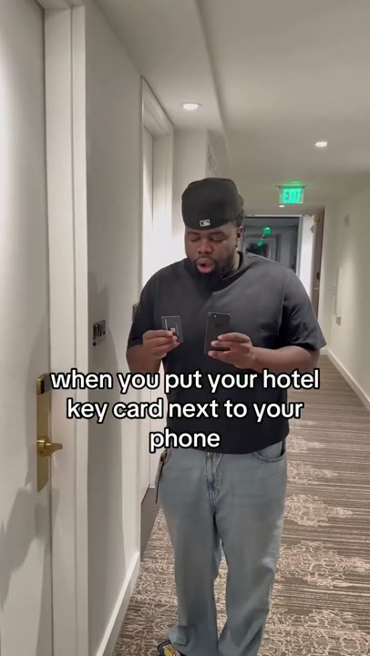 Frame at 3 seconds: The creator raises a phone and key card and looks at them with an open mouth.