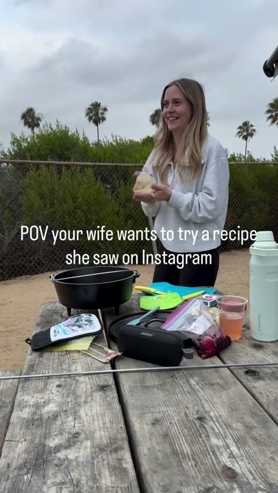 Frame at 3 seconds: The creator smiles and handles ingredients at the picnic table while another person helps.