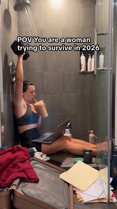 Frame at 1 seconds: The creator drinks while raising and lowering a dumbbell beneath running shower water, with a laptop already open on…
