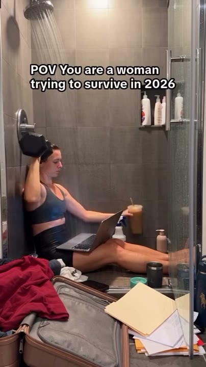 Frame at 2 seconds: The creator sets down the drink and operates the laptop while continuing the dumbbell movement.